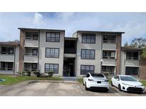 Two-story condo building with parking and landscaping at 4601 Cason Cove Dr # 214, Orlando, FL 32811