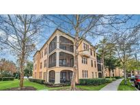 Tan three-story building with balconies and lush landscaping at 513 Mirasol Cir # 101, Celebration, FL 34747