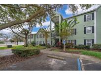 View of the green exterior of this apartment building with convenient parking in front at 2007 Dixie Belle Dr # 2007A, Orlando, FL 32812