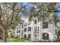 Charming white townhomes with black shutters and red tile roofs nestled among mature trees at 234 N Glenwood Ave # 4, Orlando, FL 32803