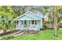 Charming light blue house with a white porch and landscaped yard at 1550 Indiana Ave, Winter Park, FL 32789