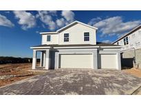New two-story home with a two-car garage and a paved driveway at 2075 Heart Lake Dr, Groveland, FL 34736