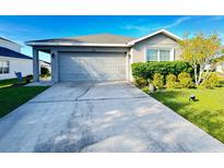 Single-story home with a two-car garage and well-maintained lawn at 2464 Deer Creek Blvd, St Cloud, FL 34772