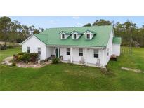 Charming farmhouse with green metal roof and inviting front porch at 3520 Hyder Ave, Deltona, FL 32738