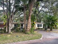 Front exterior view of a single-story home with a driveway, landscaping, and trees at 826 Rosalia Dr, Sanford, FL 32771
