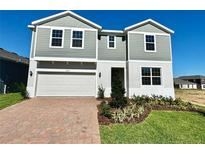Charming two-story home with gray siding, white trim, and a paved driveway at 14568 Crestavista Ave, Clermont, FL 34714