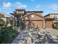 Two-story home with a two-car garage, driveway, and landscaped front yard at 148 Harwood Cir, Kissimmee, FL 34744