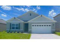 Charming two-story home with a welcoming front porch and landscaped yard at 2113 Pigeon Plum Dr, Haines City, FL 33844