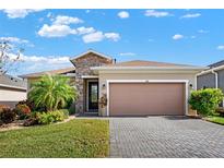 One-story home with stone accents and landscaped yard at 440 Alcove Dr, Groveland, FL 34736