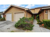 Tan two-story townhome with attached garage and walkway at 707 Carpenters Way # 45, Lakeland, FL 33809