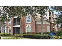 Attractive multi-story condo building with balconies and lush landscaping at 8252 Civita Dr # 201, Davenport, FL 33896