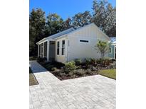 Charming beach house with landscaped yard and paved walkway at 12143 Grand Oak Ln, Oxford, FL 34484