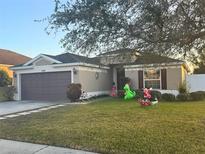 One-story home with attached garage, manicured lawn, and festive holiday decorations at 430 Dagama Dr, Clermont, FL 34715