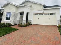 Two-story home with stone accents and a brick driveway at 5015 Dancy Ln, St Cloud, FL 34772