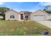 Charming single-story home with a two-car garage and landscaped front yard at 686 Cotulla Dr, Kissimmee, FL 34758