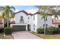 Two-story house with white walls, brown garage door, and a red tile roof at 11410 Rapallo Ln, Windermere, FL 34786