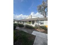 Charming single-story home with a white brick exterior, a covered entryway, and landscaping at 3076 Plaza Terrace Dr # 3076, Orlando, FL 32803