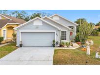 Gray house with a two-car garage and landscaping at 3965 Journey Ct, Casselberry, FL 32707