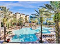 Resort-style pool with lounge chairs and palm trees at 12521 Floridays Resort Dr # 207F, Orlando, FL 32821