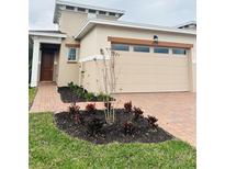 Two-story home with attached garage and landscaped front yard at 2335 Datura Loop, St Cloud, FL 34772