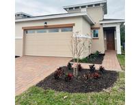 Tan two-story house with a two-car garage and landscaped front yard at 2337 Datura Loop, St Cloud, FL 34772
