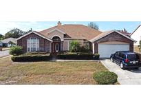 Charming single-story home with brick exterior, landscaped yard, and attached two-car garage at 4706 Beagle St, Orlando, FL 32818