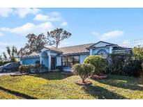 Single-story house with blue accents, a two-car garage, and a well-manicured lawn at 532 Maricopa Dr, Kissimmee, FL 34758