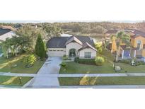 Aerial view of a single-story home with a tile roof, driveway, and landscaped yard at 2920 Orangebud Dr, Kissimmee, FL 34746