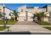 Two-story townhome with attached garage and landscaping at 781 Ocean Course Ave # 601, Davenport, FL 33896