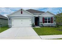 One-story home with gray siding, white garage door, and red shutters at 811 Turner Ln, Winter Haven, FL 33881