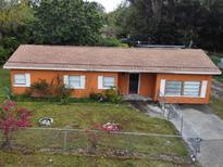 Orange house with a brown roof and fenced yard at 5165 Gwynne Ave, Orlando, FL 32810