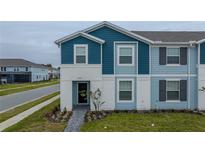 Two-story townhome with blue siding, a walkway, and landscaping at 4250 Lana Ave, Davenport, FL 33897