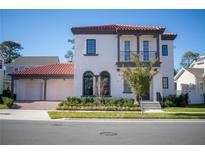 Two-story house with red tile roof, two-car garage, and landscaping at 7493 Estuary Lake Loop, Kissimmee, FL 34747