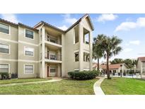 Exterior view of a condo building with landscaping and a pool at 3032 Parkway Blvd # 302, Kissimmee, FL 34747