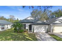 White house with gray roof, one-car garage, and landscaped lawn at 927 Pecan St, Oviedo, FL 32765