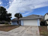 Cute light blue house with a white garage door and palm tree at 762 Rosalie Way, Winter Springs, FL 32708
