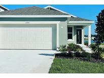 New construction home with two-car garage and landscaped yard at 1260 Regal King Dr, Kissimmee, FL 34746