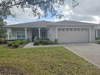 Tan one-story house with a two-car garage and landscaped front yard at 501 Heritage Trail St, Kissimmee, FL 34759