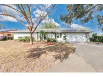 Ranch-style home with mature landscaping and a long driveway at 7201 Pleasant Dr, Orlando, FL 32818