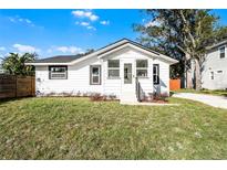Charming bungalow with a renovated exterior, featuring a white facade and landscaped lawn at 1441 Dann St, Orlando, FL 32804
