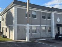 Exterior view of a light gray building with several windows and a small parking lot at 2761 L B Mcleod Rd # C, Orlando, FL 32805