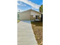 Newly constructed light brown house with a concrete driveway and a small yard at 322 N 6Th St, Haines City, FL 33844