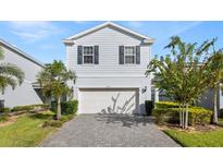 Two-story house with gray siding, white garage door, and landscaped front yard at 1627 Kona Ln, Davenport, FL 33897