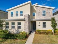Two story home with stone and light colored siding at 4563 Narrative Ln, Kissimmee, FL 34746