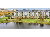 Aerial view of a modern apartment building near a lake at 7573 Laureate Blvd # 1207, Orlando, FL 32827
