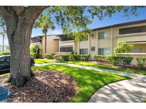Attractive condo building with lush landscaping and a walkway at 6110 Curry Ford Rd # 219, Orlando, FL 32822