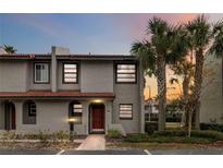 Two-story condo with a red door and palm trees in front at 2007 Disney Mgm Studio Ct, Kissimmee, FL 34746