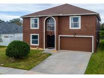 Two-story brown house with a two-car garage and landscaping at 224 Fairfield Dr, Sanford, FL 32771