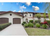Two-car garage, attractive landscaping, and a Spanish-style facade at 104 Coventry Ln, Haines City, FL 33844