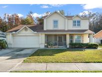 Two-story house with attached garage and landscaped lawn at 112 Blackwater Ct, Kissimmee, FL 34743